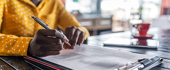 African-American woman filling out paperwork in a coffeeshop