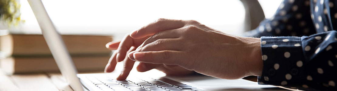 Woman typing on a laptop keyboard.